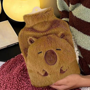 Fluffy brown hot water bottle with bear design held by a hand on a textured surface.
