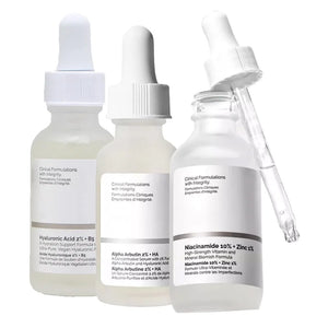 Three skincare serum bottles with droppers on a white background