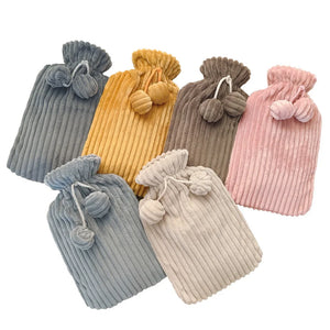 Set of colorful ribbed hot water bottles with pom-pom ends on a white background